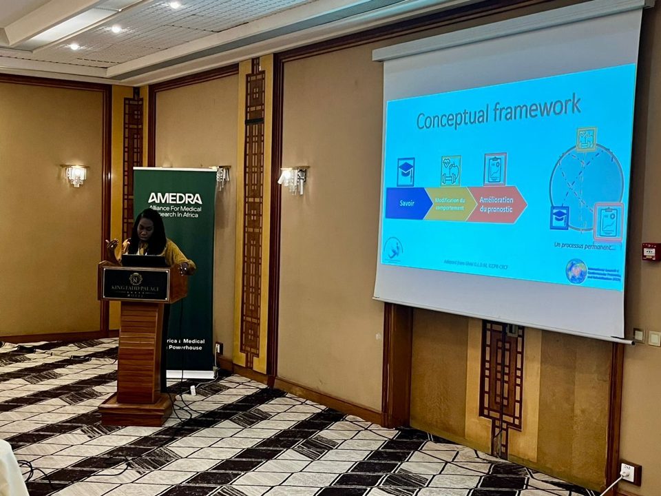 A presenter at the podium during the scientific session on non-communicable disease research in Dakar